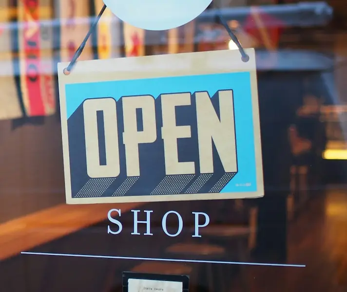Open sign hanging in the window of a local shop