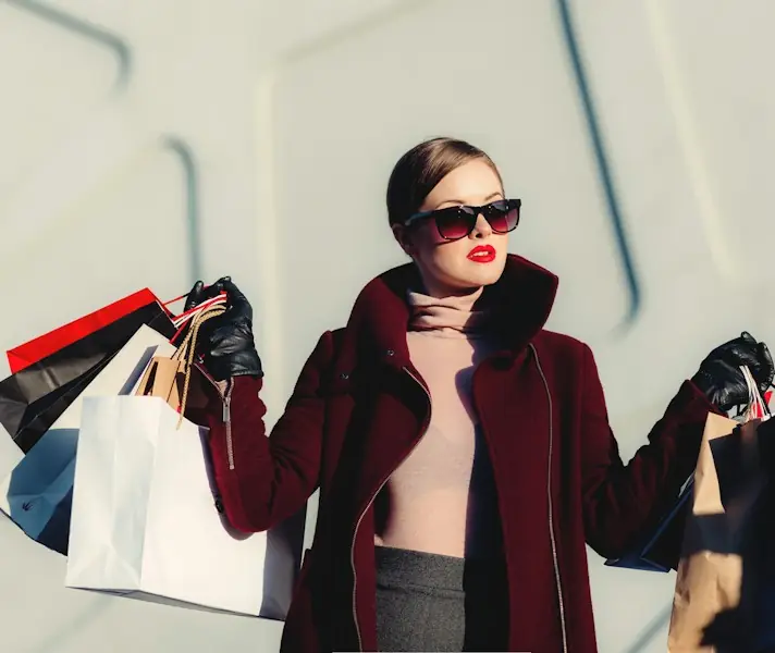 Shopper carrying several paper shopping bags