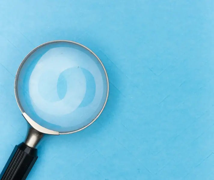 Magnifying glass lying on a bright blue surface
